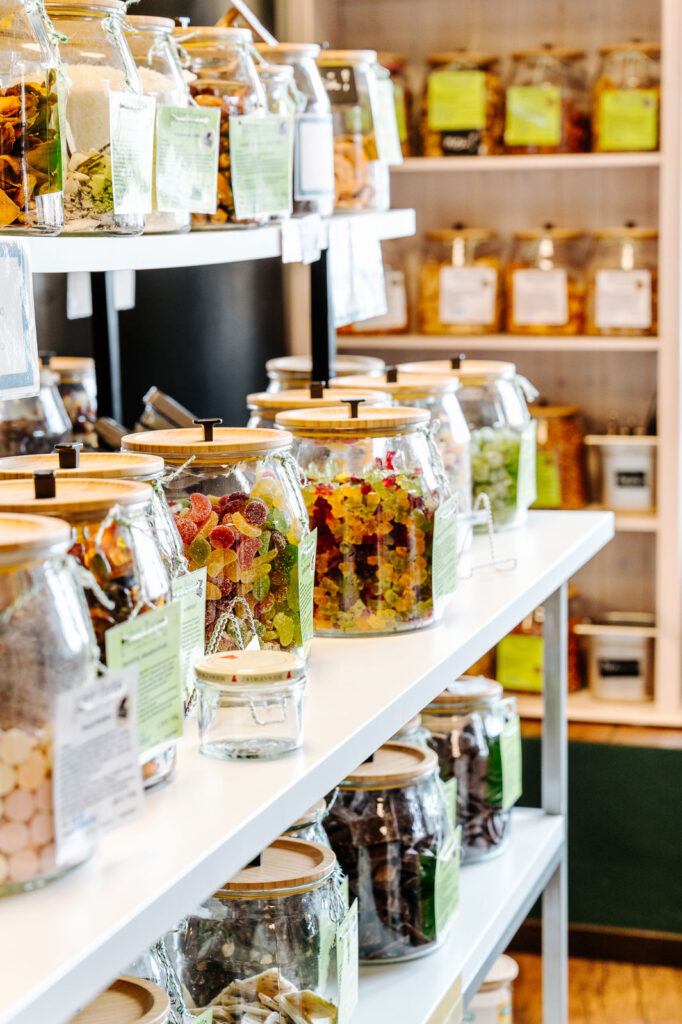 Regal mit Gläsern und Holzdeckel, in dem sich Fruchtgummi und Nascherein befinden.